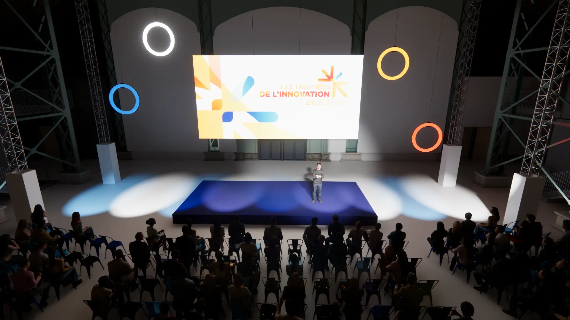 La cérémonie des Trophées de l’Innovation : l’orateur sur l’estrade sous les anneaux lumineux colorés